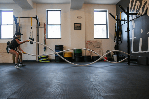 Frau mit Battlerope, HIIT Training